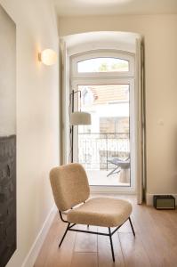 a chair in a room with a window at Villa Sofia Cascais in Cascais
