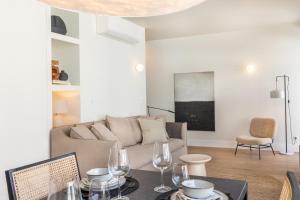 a living room with a couch and a table with wine glasses at Villa Sofia Cascais in Cascais
