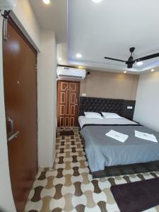 a bedroom with a bed and a brown door at Le Luminous, Home Stay in Port Blair