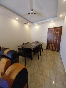 a room with a table and chairs and a door at Le Luminous, Home Stay in Port Blair