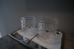 dos jarrones de cristal sentados en una bandeja sobre una mesa en Vip Avtim hotel, en Uzhhorod