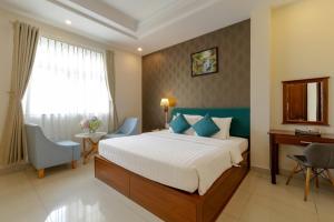 een slaapkamer met een bed, een bureau en een raam bij Airport Saigon Hotel - Gần ẩm thực đêm chợ Phạm Văn Hai in Ho Chi Minh-stad