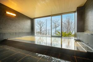 an empty room with a large window and water at Lake Toya Villa SUSUKIAN in Sobetsu