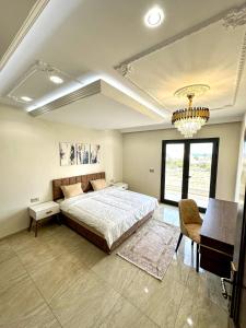 a bedroom with a large bed and a chandelier at Luxury 3 Bedrooms apartment Sea View, Central AC, WiFi in Rejiche
