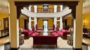 un vestíbulo con muebles rojos y paredes amarillas en Heritage Luxury Suites All Suite Hotel en Lahore