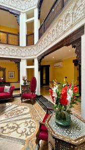 a lobby with a vase of flowers on a table at Heritage Luxury Suites All Suite Hotel in Lahore