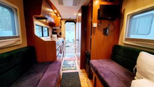 a small room with two benches and a kitchen at Que Camper Ct Full Bath in New Haven