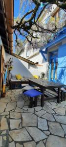 uma mesa de piquenique e um banco num pátio de pedra em h2oholidays - auberge de jeunesse - youth hostel em Capbreton
