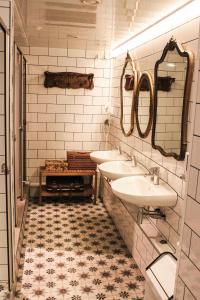 a bathroom with two sinks and two mirrors at Pars Teatro Hostel in Barcelona