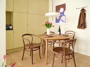 une table à manger et des chaises avec un vase de fleurs dans l'établissement Apēron Apartment Hotel, à Copenhague