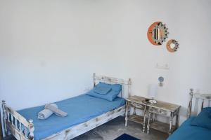 a bedroom with a bed with blue sheets and a table at Afroditi Ground floor apartment in Achílleion