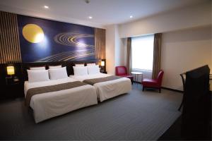 una camera d'albergo con 2 letti e una scrivania di Hotel Bestland a Tsukuba