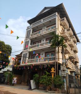 a tall white building with balconies on a street at Beat Hotel Siem Reap in Siem Reap