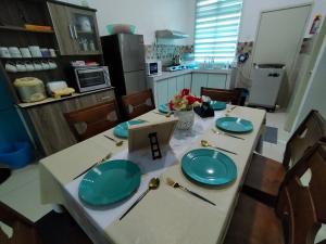 a kitchen with a table with blue plates on it at Homestay 88A Melaka for 9 pax with Smart TV and Netflix and wifi in Melaka