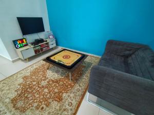 a living room with a couch and a table and a tv at Homestay 88A Melaka for 9 pax with Smart TV and Netflix and wifi in Melaka