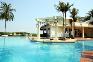 una piscina frente a una casa con palmeras en Riverside Serviced Apartments, en Ho Chi Minh
