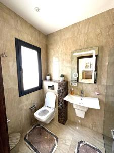 ein Badezimmer mit einem WC, einem Waschbecken und einem Spiegel in der Unterkunft Luxury Sea View 3 Bedrooms, Central AC, WiFi in Rejiche