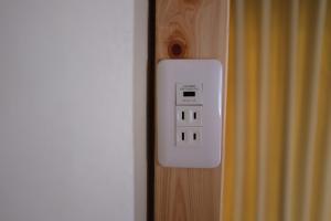 toma de corriente eléctrica en una pared de madera con puerta en Azumino Fukuro Guesthouse - Vacation STAY 21913v, en Azumino