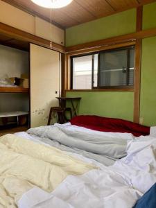 ein großes weißes Bett in einem Zimmer mit Fenster in der Unterkunft Shonan no Oka no Villa - Vacation STAY 24013v in Fujisawa