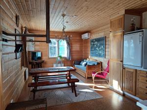 a living room with a table and a tv at Saaristotila Jackois in Iniö