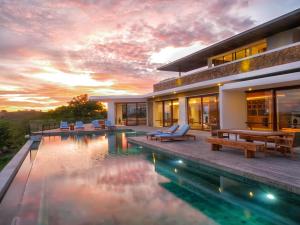 una casa con piscina y puesta de sol en Jeeva Mandalika, en Kuta Lombok