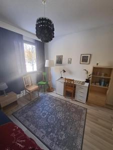 a living room with a rug and a table and a desk at Room in Polar Circle in Rovaniemi