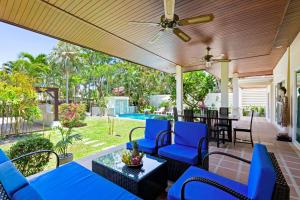 ラワイビーチにある3BR Villa Barnabé with Lush Gardenのポーチ(青い椅子、天井ファン付)