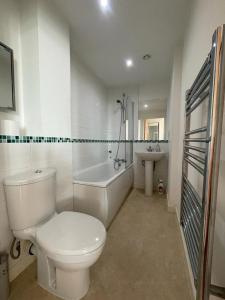 een badkamer met een toilet, een bad en een wastafel bij Nottingham City Centre Apartment in Nottingham
