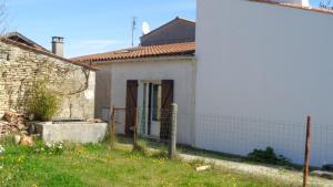 una pequeña casa blanca con una valla delante en Maisonnette Saint-Georges-d'Oléron 17590 à Sauzelle 2 , 3 personnes en Foulerot