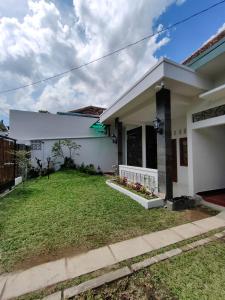 a house with a lawn in front of it at Sekar Tanjung in Yogyakarta
