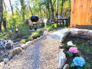 a backyard with a grill and some flowers at Chalet Privé Cosy in Malaussène