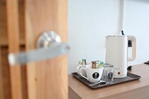 a coffee maker on a counter with cups on it at T-OneHome in Phetchabun