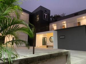 a black and white house with a palm tree at T-OneHome in Phetchabun