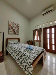 a bedroom with a large bed with a blue towel on it at Sekar Tanjung in Yogyakarta