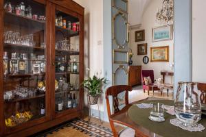 un comedor con una mesa y un armario lleno de gafas en Palazzo Guido, en Lecce