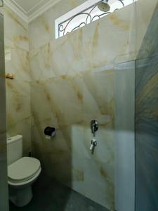 a bathroom with a toilet and a glass shower at Sekar Tanjung in Yogyakarta +21 photos