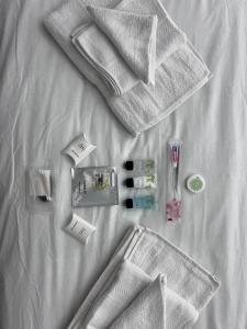 a group of white towels and cosmetics on a bed at Woolaway in Taunton