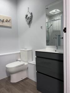 a white bathroom with a toilet and a sink at Woolaway in Taunton