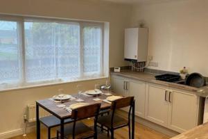 a kitchen with a table with two chairs and a kitchen with a counter at Plum Tree Corner in Chapel Saint Leonards