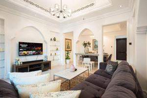a living room with a couch and a tv at Tranquil Oasis- 2Bedroom, Connected to Dubai Mall in Dubai