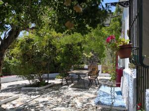 un patio con tavolo, sedie e alberi di Cortijo Buena Vista a Laroles