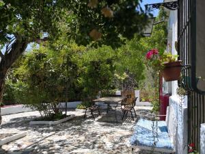 a patio with a table and chairs and trees at Cortijo Buena Vista in Laroles