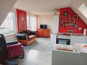 a kitchen and living room with red walls at Ferienwohnung auf dem Land Mecklenburgische Seenplatte Müritz, ländliche Region in Below