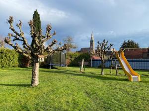 a playground with a tree and a slide at Holz Fässla in Wolframs-Eschenbach