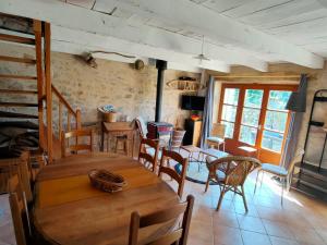 a dining room with a wooden table and chairs at la bergerie de papé in Vimenet