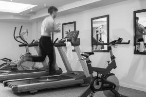a man on two exercise bikes in a gym at Princess Resort, Santikos Collection in Agia Paraskevi