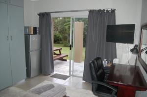 a living room with a refrigerator and a sliding glass door at Nita's Air Bed & Breakfast & self catering in Crocodile Valley Estates