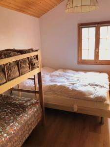 a bedroom with two bunk beds and a window at Alphütte Riederalp Planier in der Aletsch Arena in Riederalp