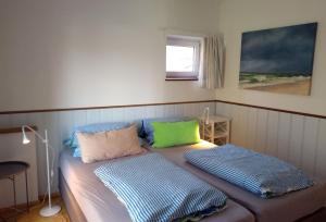uma cama com duas almofadas num quarto em Lütt Logis in Grödersby em Grödersby