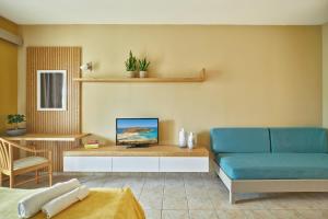 a living room with a blue couch and a table at Pegasus Hotel in Stalos